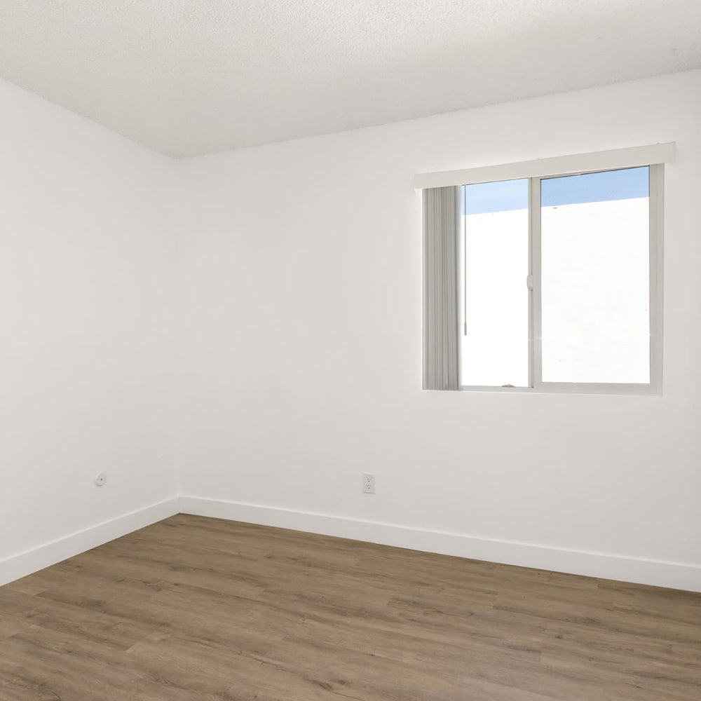 Empty white room with a window and wooden floor at Valle at Mission in Escondido, California