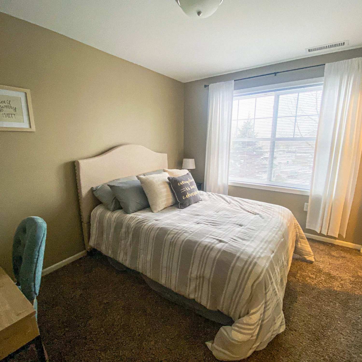 Bedroom with sunlit window at The Quarters Mankato in Mankato, Minnesota