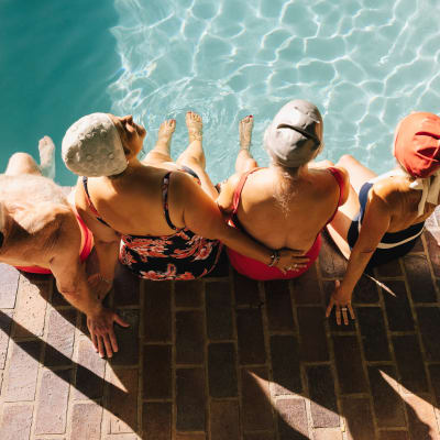 Ladies with swim caps on at pool's edge ready for their morning exercise at Aero Apartments in Davis, California