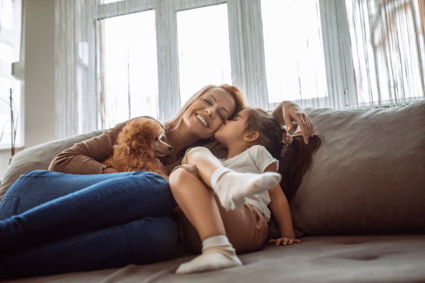 Little girl kissing her mother at Villas at Chase Oaks in Plano, Texas