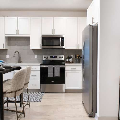 Kitchen with wood flooring and modern features in a model home at The Station at Fleming Island in Fleming Island, Florida