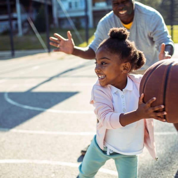 Residents playing basketball near Wood Crest Apartment Homes in Chalmette, Louisiana