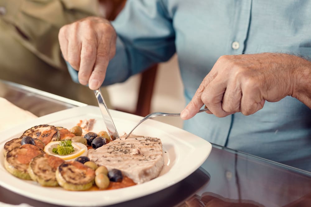 Senior eating a salmon dish at a Randall Residence community