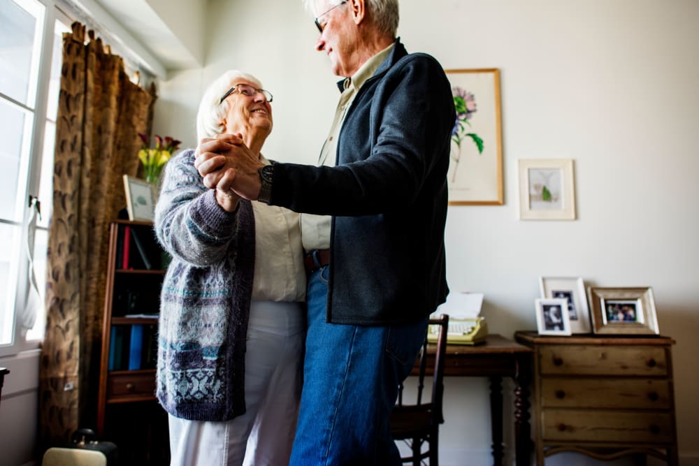 Two seniors dancing in their new apartment at a Randall Residence community