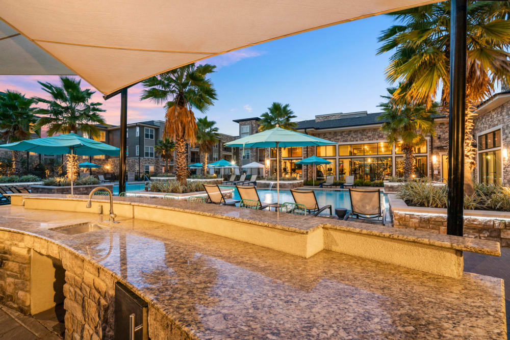 Outdoor kitchen by pool at Olympus Grand Crossing in Katy, Texas