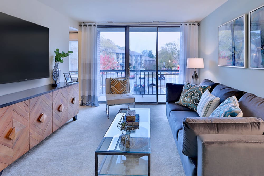 Spacious living room opening onto a private balcony at Chesapeake Glen Apartment Homes in Glen Burnie, Maryland