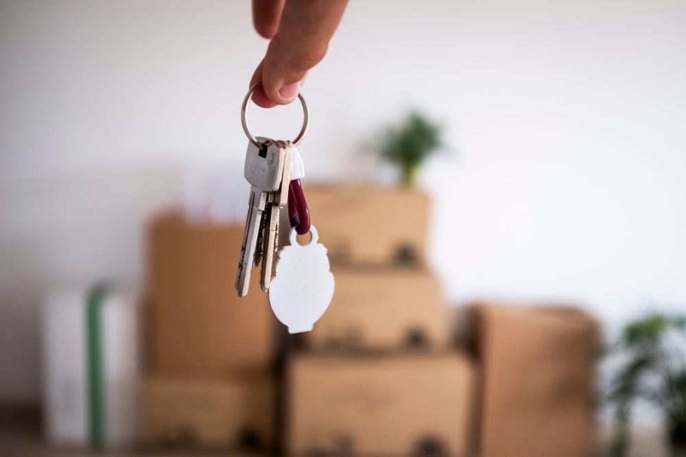 Keys held in front of a stack of boxes at Our Self Storage.