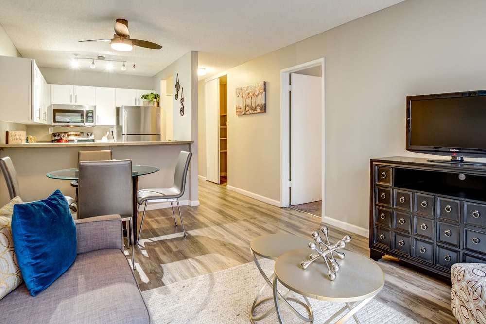 Open living room and kitchen of a model apartment with wood-style plank flooring at Parc Station in Santa Rosa, California