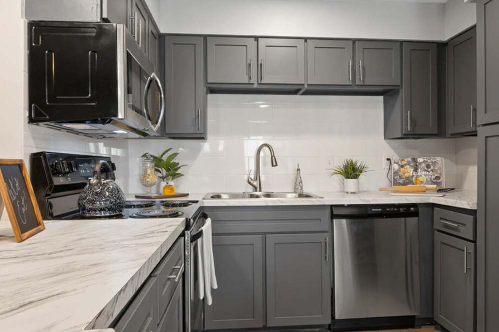 Spacious kitchen with stainless-steel appliances, granite countertops and wooden cabinets at Hill At Woodway in San Antonio, Texas