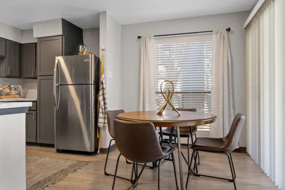 Dining area with a round table, chairs and a large window at Hill At Woodway in San Antonio, Texas