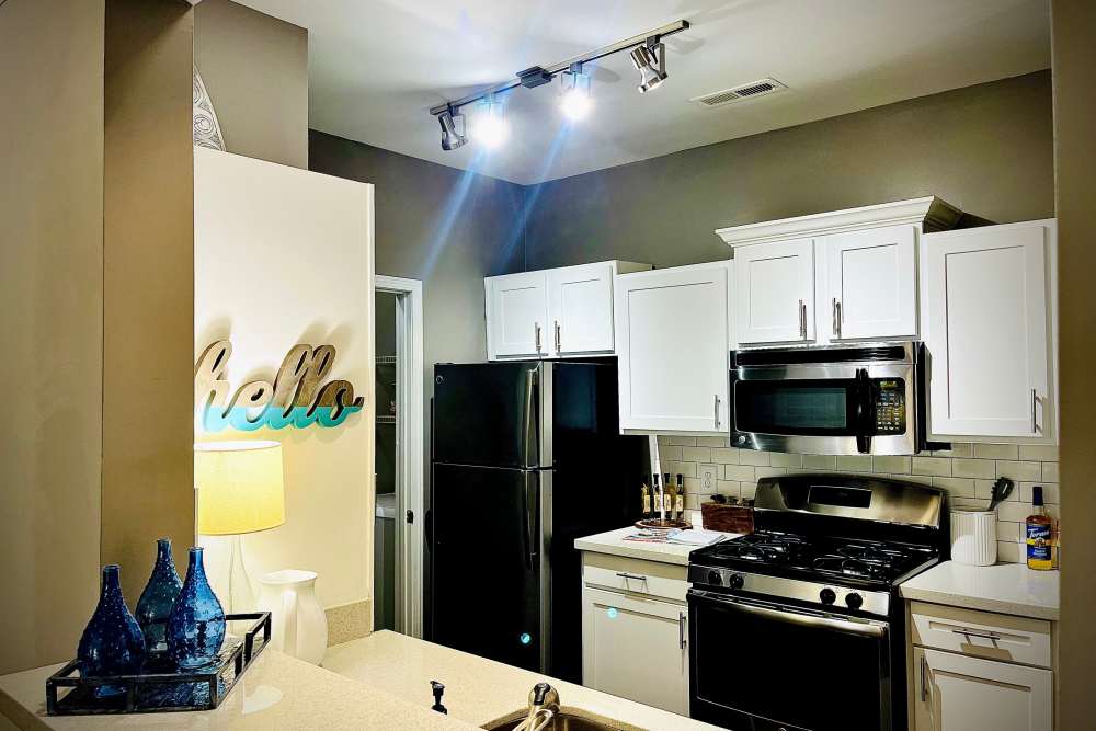 Black appliances and white cupboards in an apartment kitchen at Retreat at Johns Creek in Duluth, Georgia