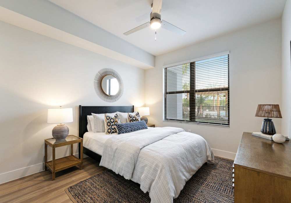 Modern bedroom with wood-style flooring at Mark Lane Apartments in Naples, Florida