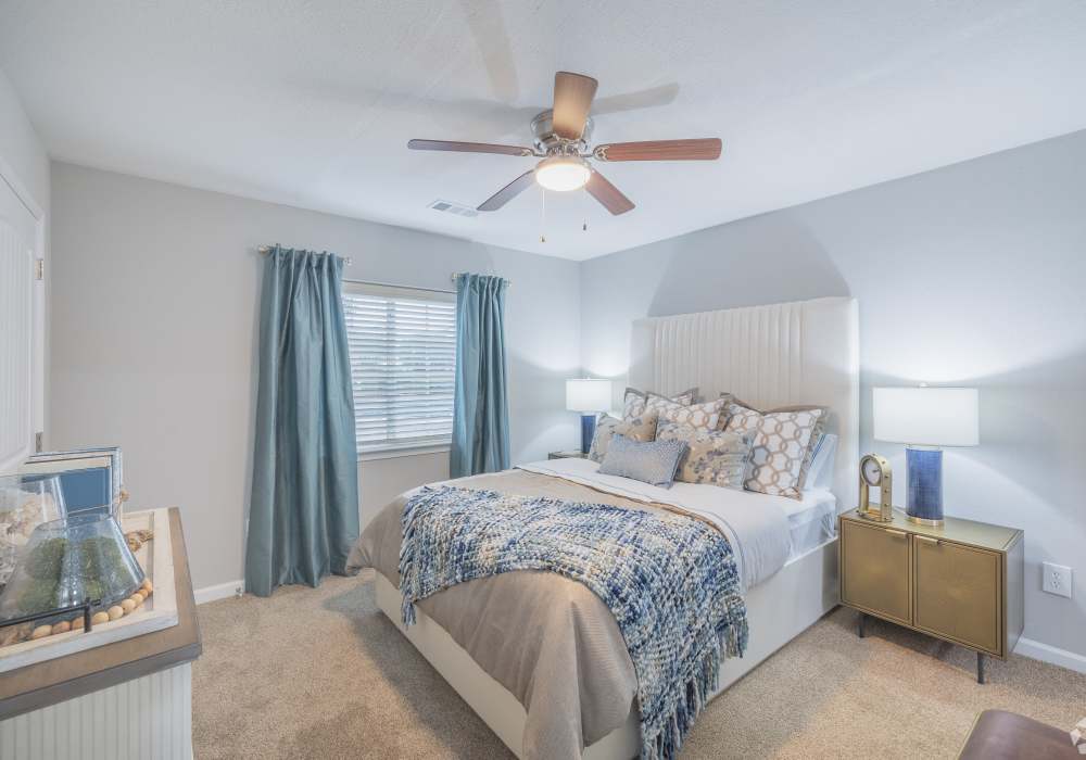 Well lit bedroom with plush carpeting spacious closets, ceiling fan, and connected bathroom at River Landing in Myrtle Beach, South Carolina
