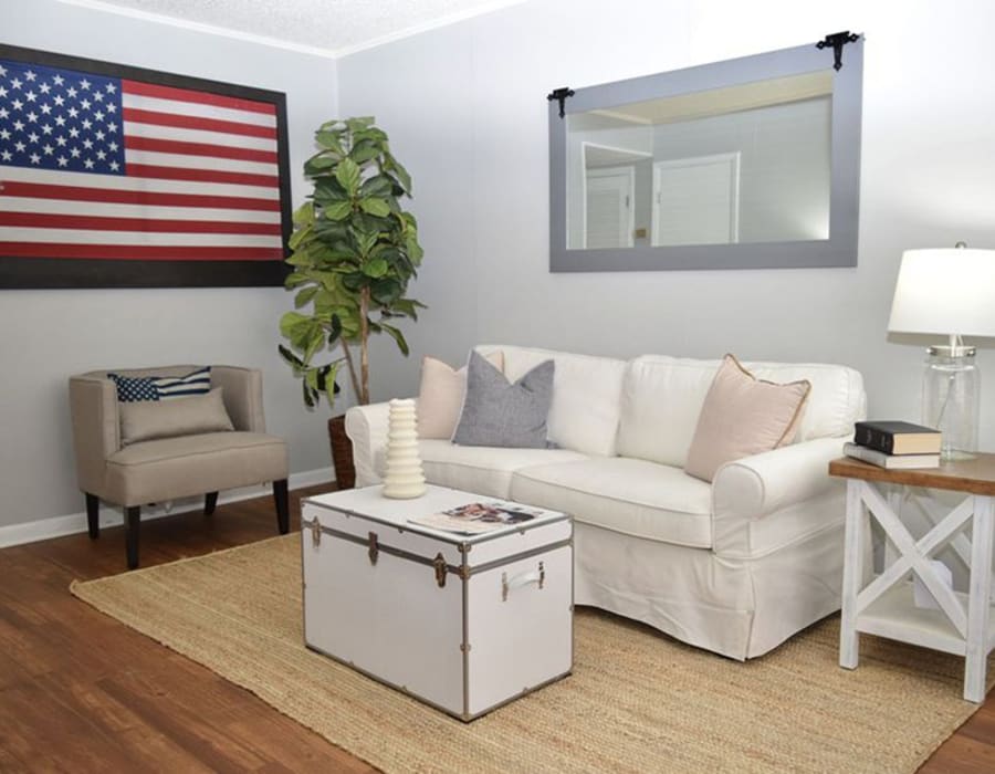 Model apartment living room with an american flag on the wall at Patriot's Place Townhomes in Goose Creek, South Carolina