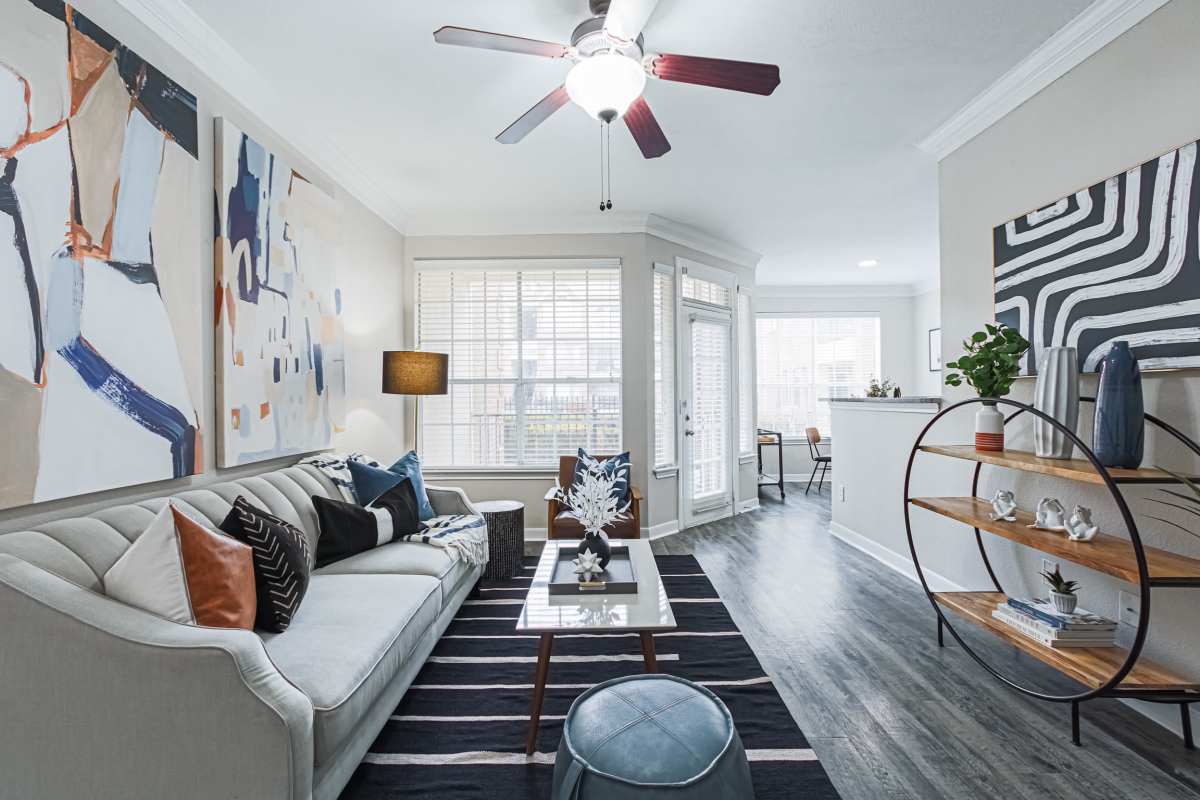 Living room with large window and beautiful rug at The Village At Bellaire Apartments in Houston, Texas