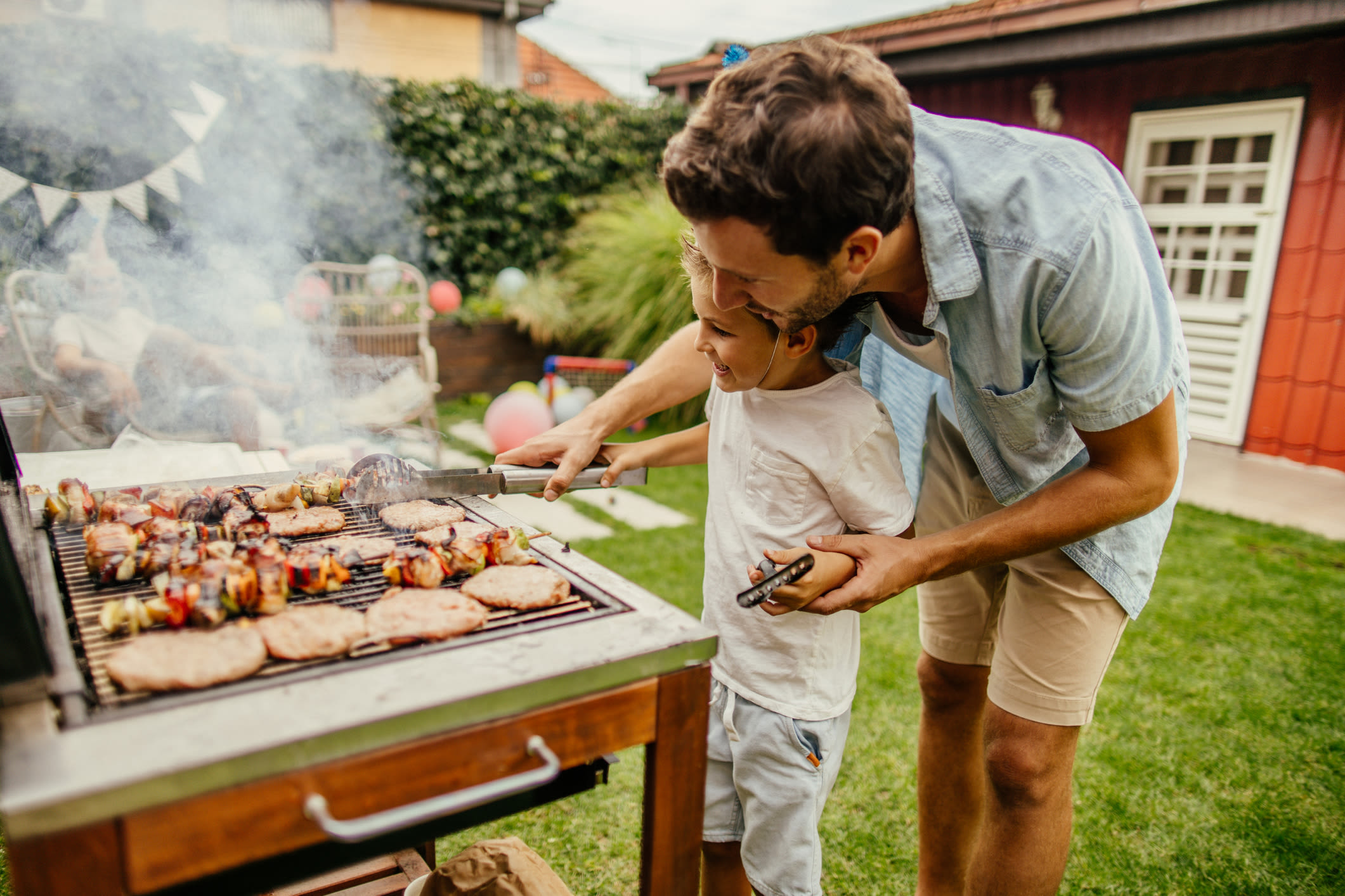 Resident cooking on the barbeque with their child at Holly Court in Pitman, New Jersey