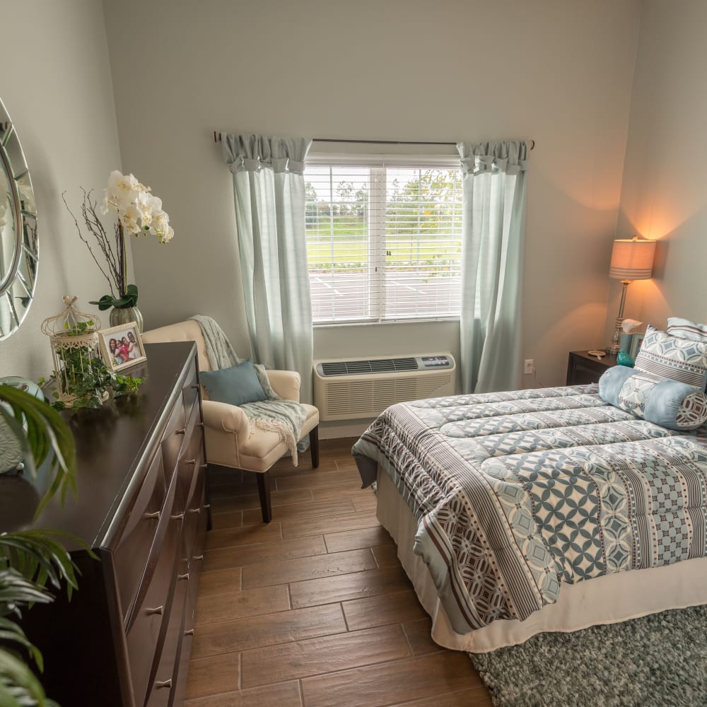 Nice bedroom with flowers and furniture in Inspired Living Lewisville in Lewisville, Texas