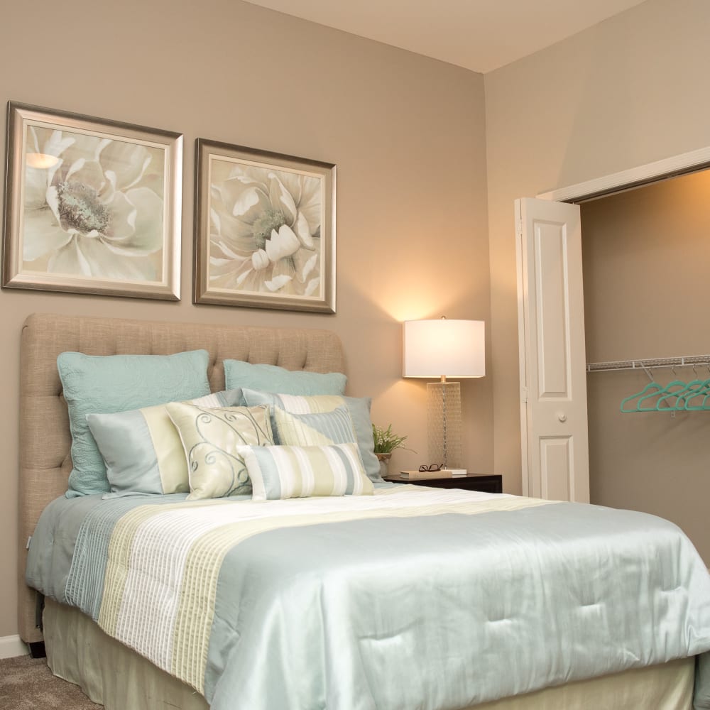 Resident bedroom with a closet and wall art at Inspired Living Sugar Land in Sugar Land, Texas