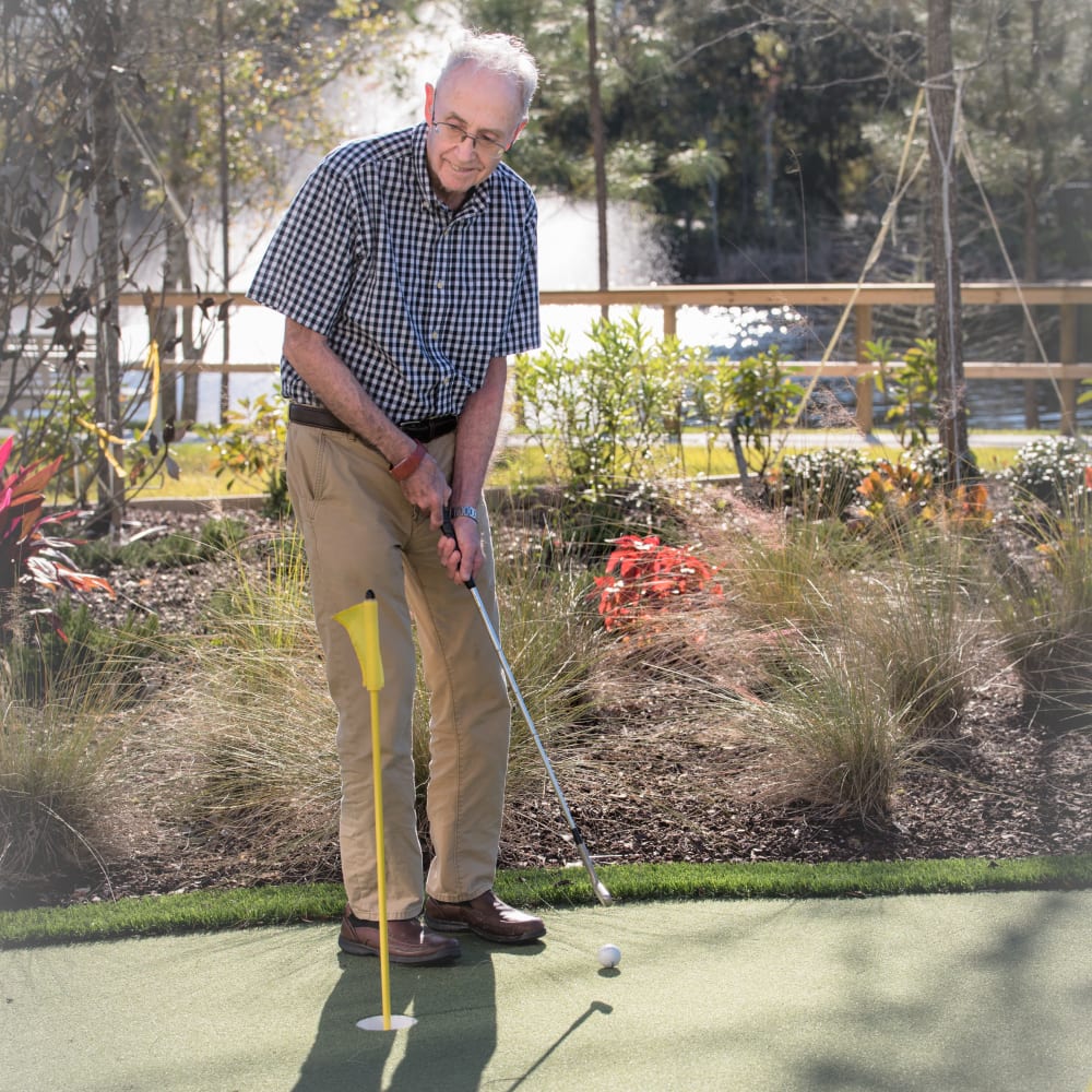 A resident on the putting green at Inspired Living Lewisville in Lewisville, Texas.