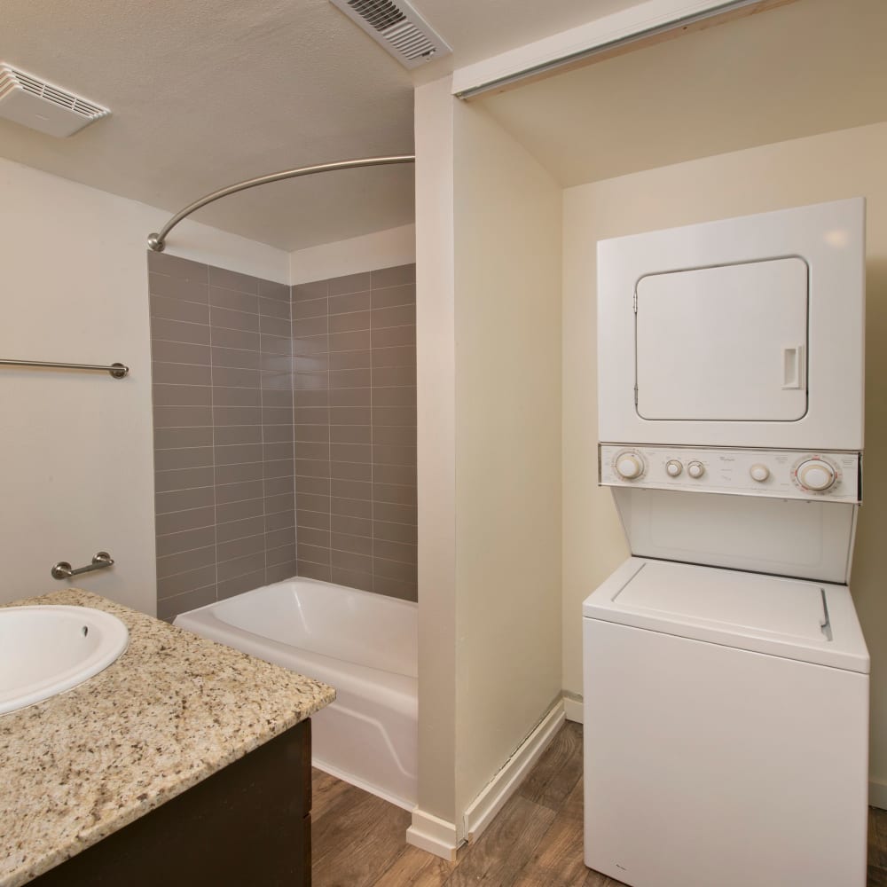 Bathroom with a stacked washer and dryer at Harrison Tower in Portland, Oregon