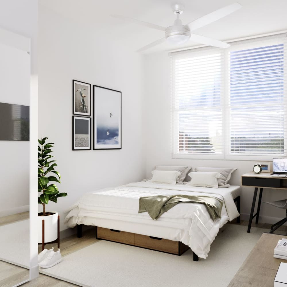 Bright bedroom with wood-style flooring at UNCOMMON Auburn in Auburn, Alabama