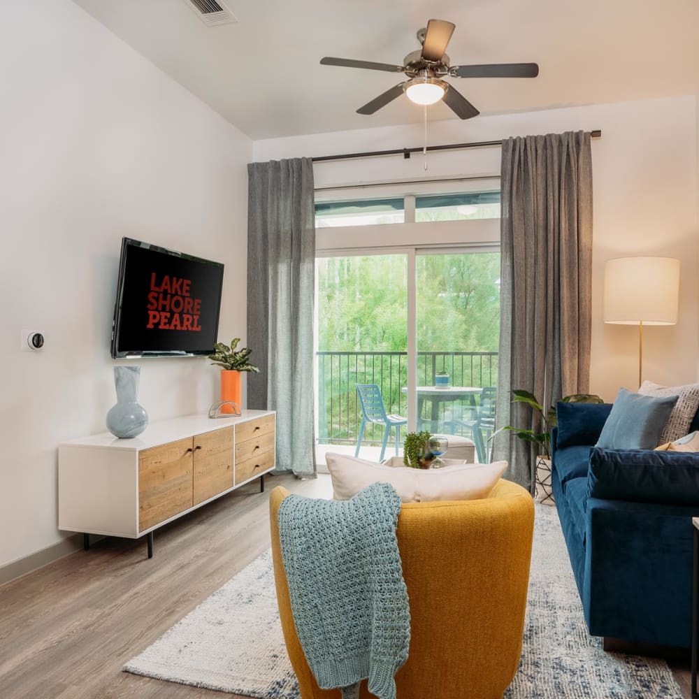 Hardwood flooring and a ceiling fan in the living area of a model home at Lakeshore Pearl in Austin, Texas