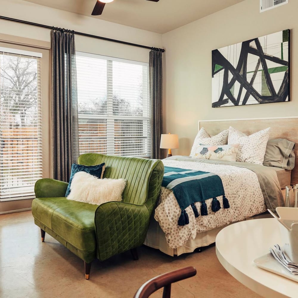 Concrete flooring and a ceiling fan in a model home's bedroom at The Guthrie in Austin, Texas