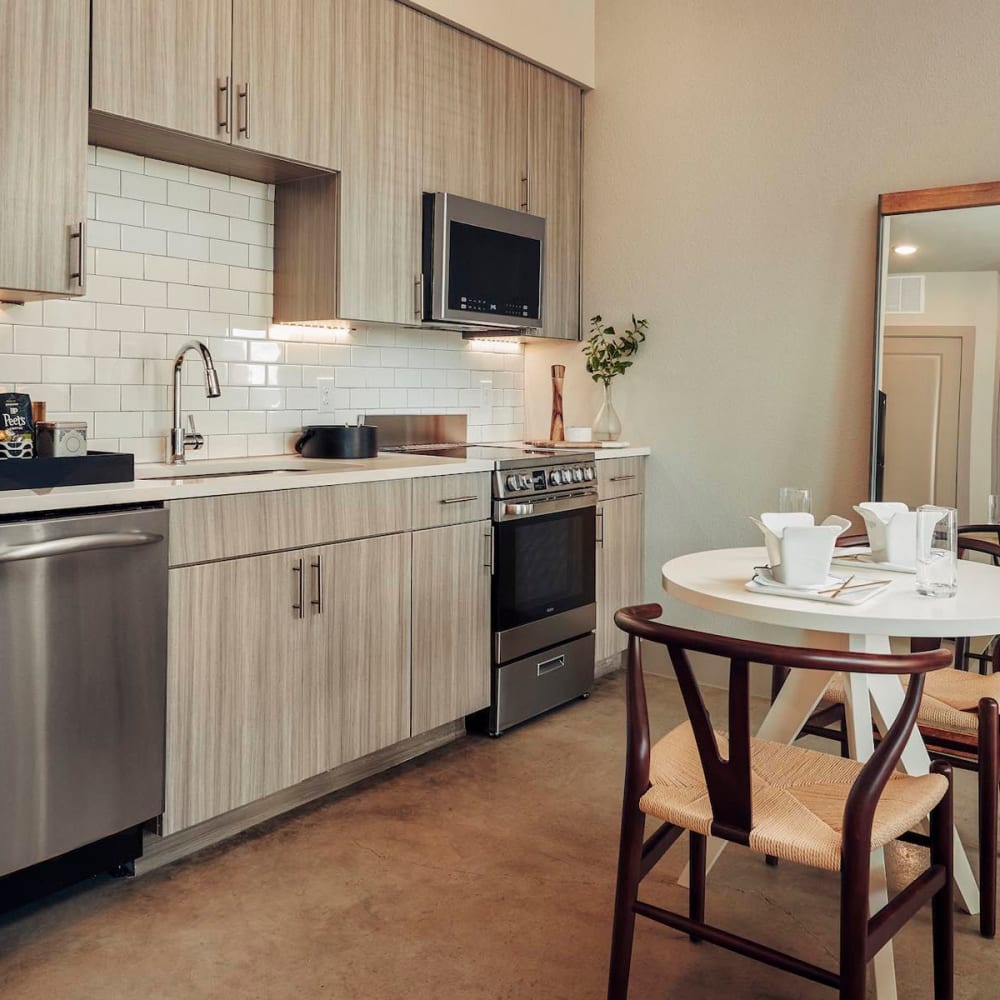 Model home's kitchen with custom wood cabinetry at The Guthrie in Austin, Texas
