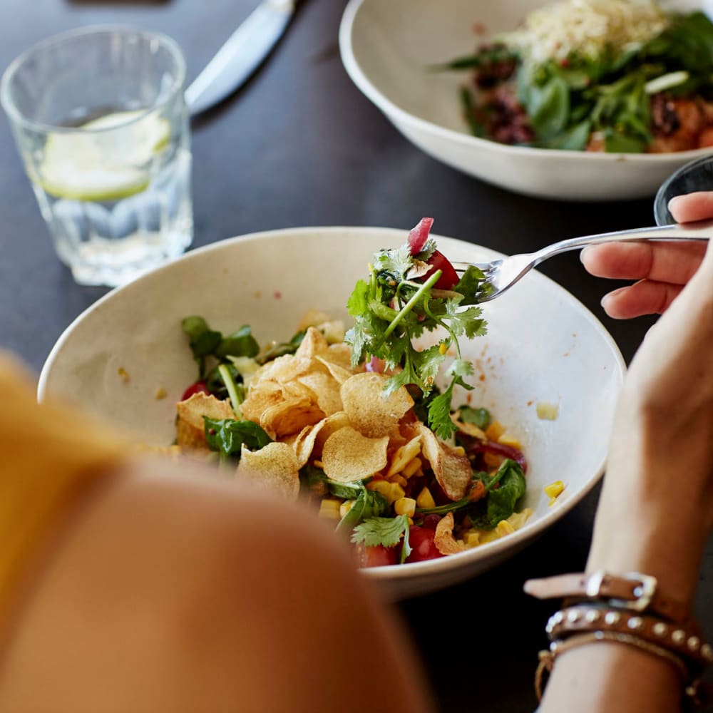 Resident enjoying a delicious lunch at a restaurant close to her downtown office near Oaks 5th Street Crossing at City Station in Garland, Texas