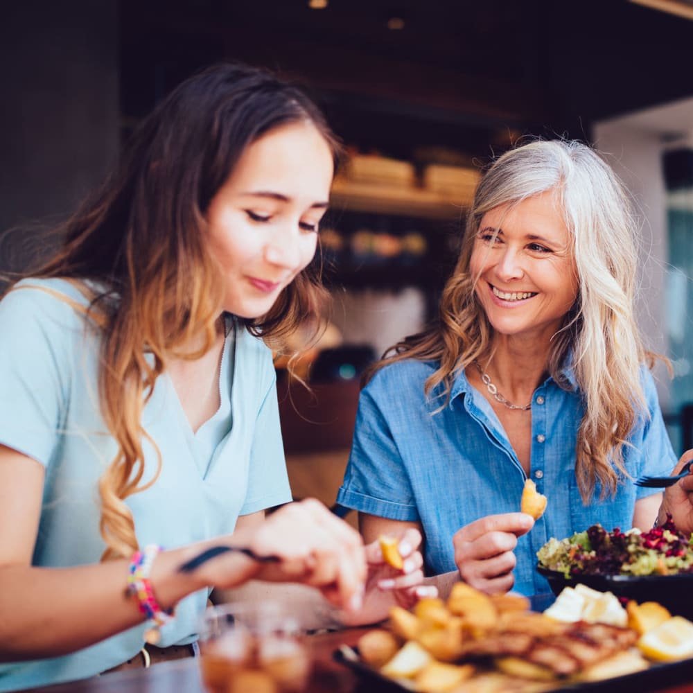 Mother and daughter enjoying lunch together at their favorite restaurant near Oaks 5th Street Crossing At City Center in Garland, Texas