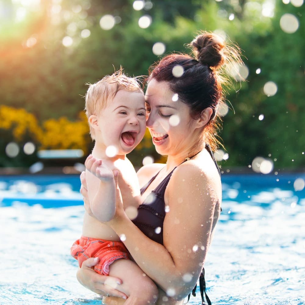 Mother and son laughing in the pool on a beautiful afternoon at Oaks Braemar in Edina, Minnesota