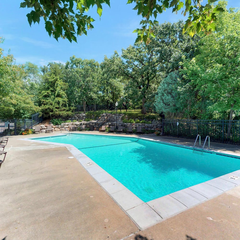 Mature trees providing shade around the swimming pool at Oaks Braemar in Edina, Minnesota