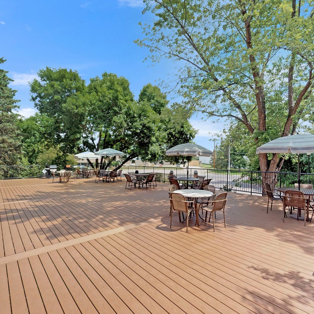 Mature trees providing shade at the decked picnic area at Oaks Braemar in Edina, Minnesota