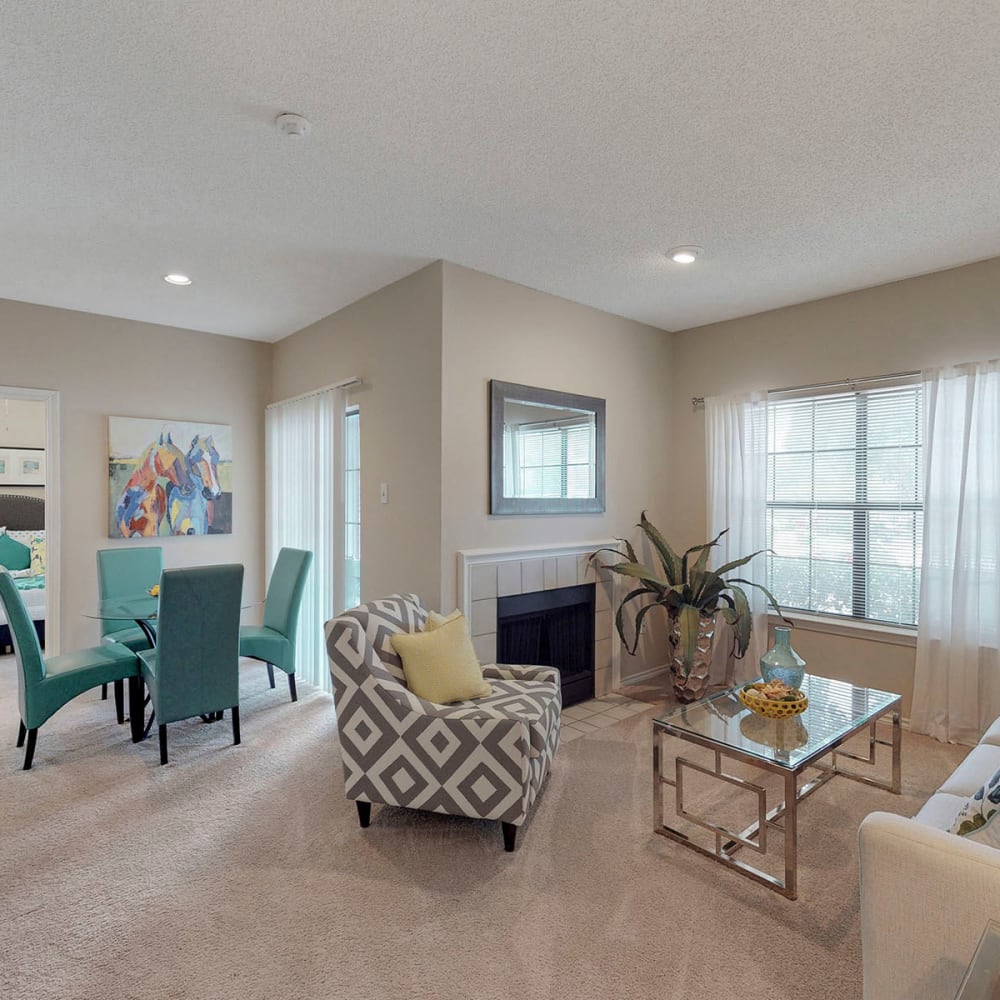 Plush carpeting and modern furnishings in the open-concept living area of a model apartment at Oaks Hackberry Creek in Las Colinas, Texas