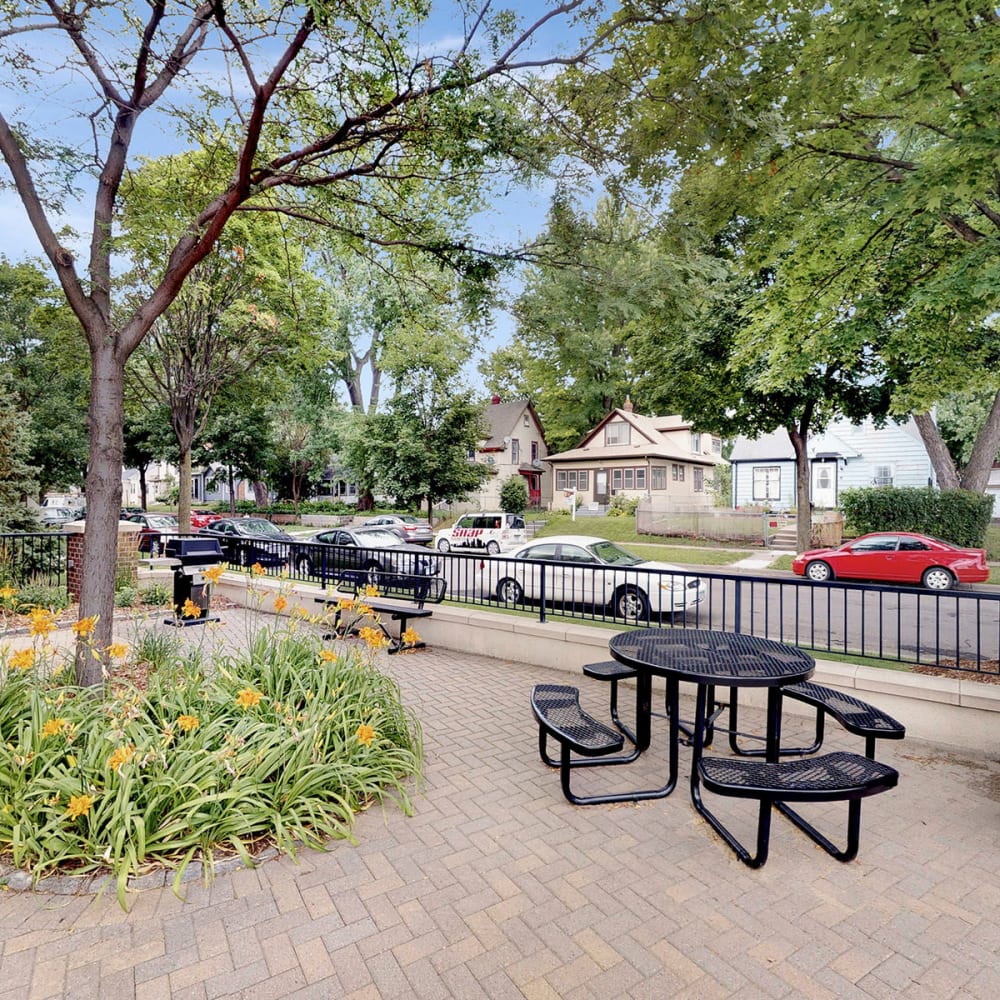 Picnic table in a courtyard surrounded by mature trees at Oaks Hiawatha Station in Minneapolis, Minnesota