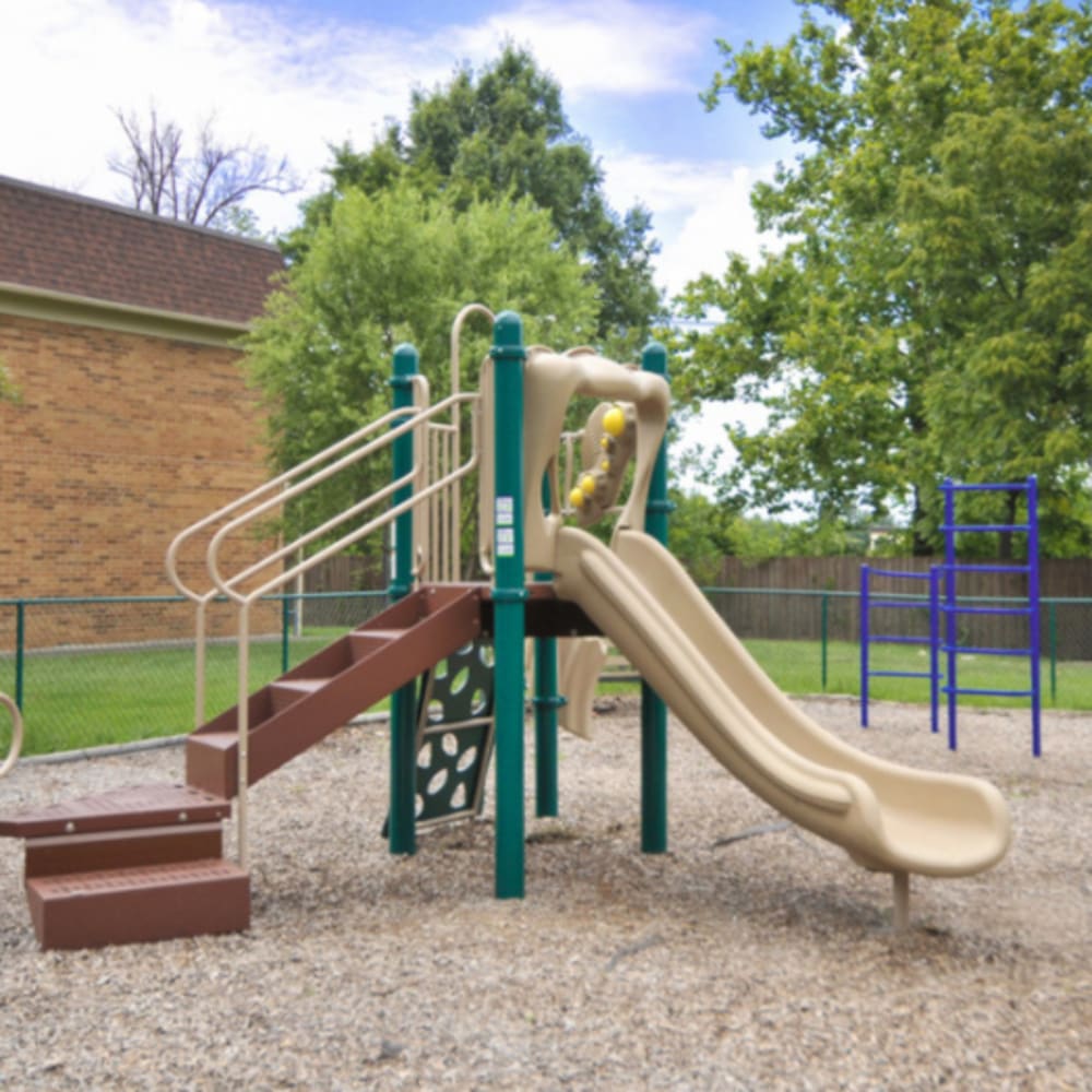 A children's playground surrounded by grass at Tanglewood Apartments in Louisville, Kentucky