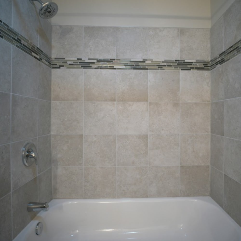 A bathroom with an oval tub and tiling at Tanglewood Apartments in Louisville, Kentucky