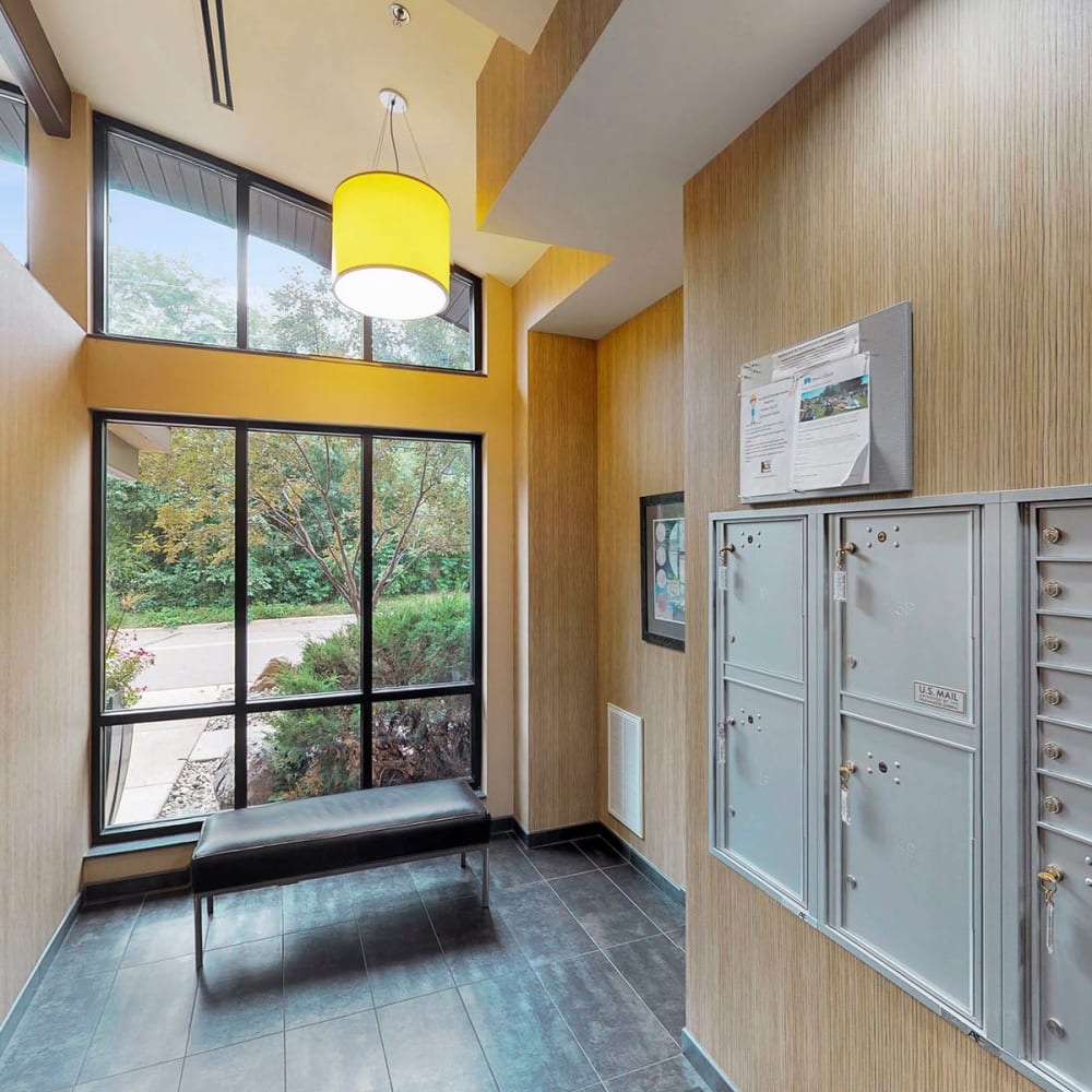 Seating area with floor-to-ceiling windows near the mailboxes at Oaks Glen Lake in Minnetonka, Minnesota