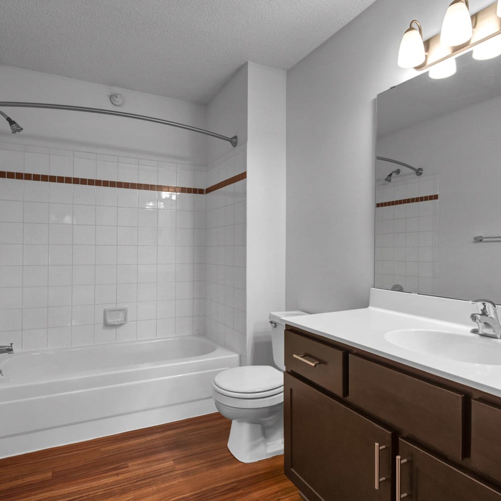 Tiled shower and a large vanity mirror in a model townhome's bathroom at Oaks Lincoln Apartments & Townhomes in Edina, Minnesota