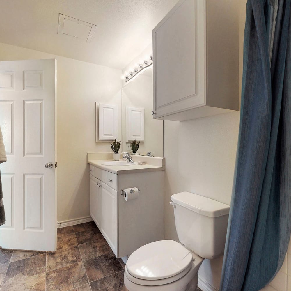 Extra storage cabinet and slate tile flooring in a model home's bathroom at Oaks Riverchase in Coppell, Texas