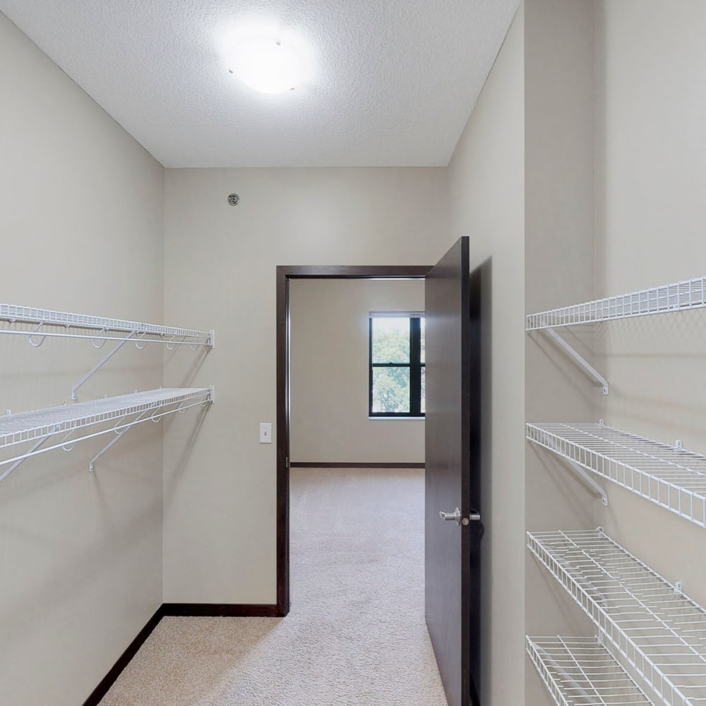 Large walk-in closet with ample shelving in a model home's primary bedroom at Oaks Station Place in Minneapolis, Minnesota