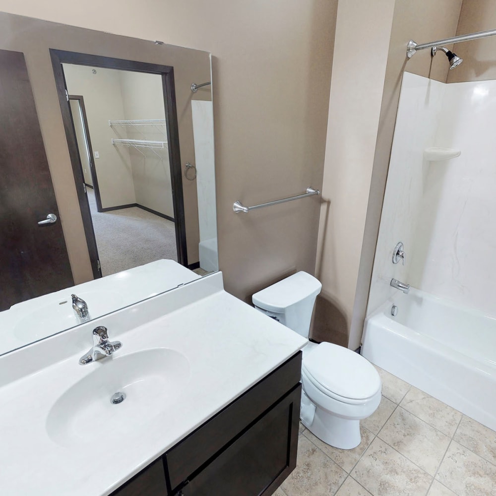 Large vanity mirror in a model apartment's main bedroom's en suite bathroom at Oaks Station Place in Minneapolis, Minnesota