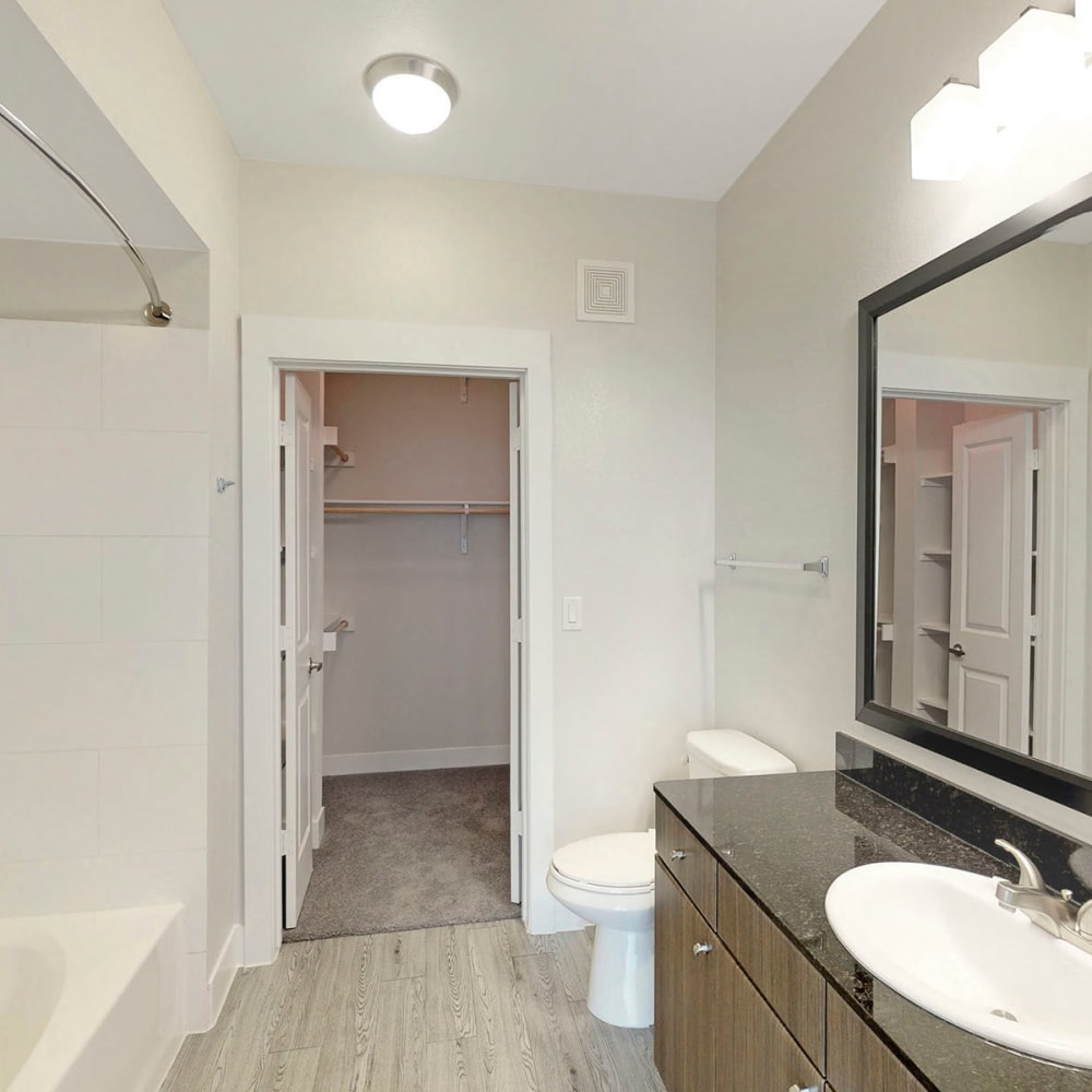 Spacious primary bedroom's en suite bathroom with a walk-in closet in a model apartment at Oaks Trinity in Dallas, Texas