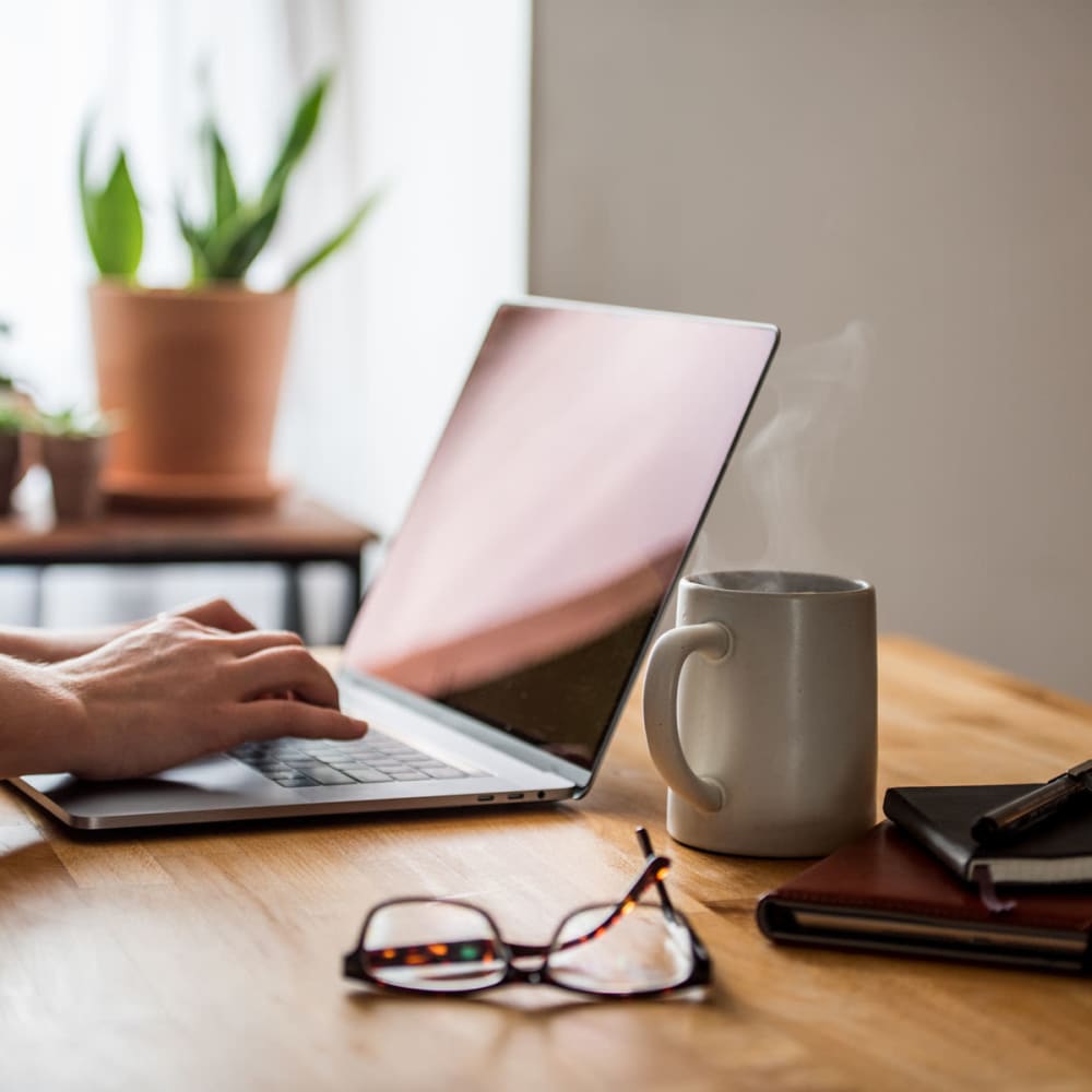 Resident working from home on a laptop in her apartment at Oaks White Rock in Dallas, Texas