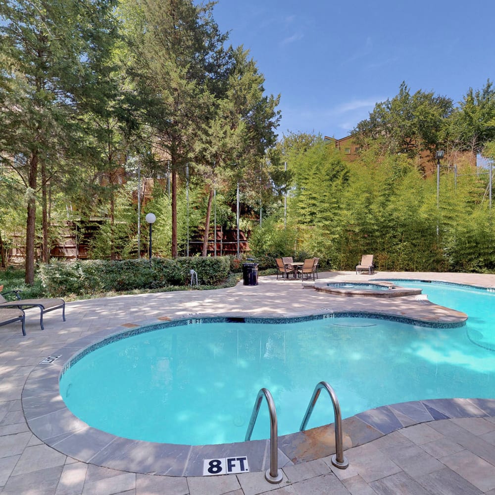 Lush tree-lined landscape around the pool at Oaks White Rock in Dallas, Texas