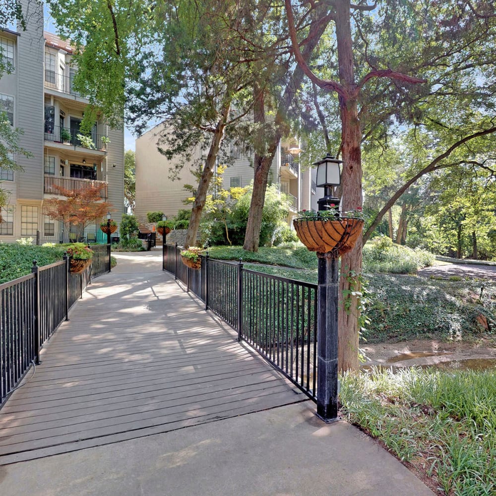 Bridge over a small stream surrounded by mature trees at Oaks White Rock in Dallas, Texas