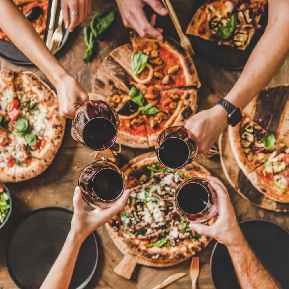 Friends enjoying wine and pizza in Winston Salem, North Carolina near The Gallery Lofts