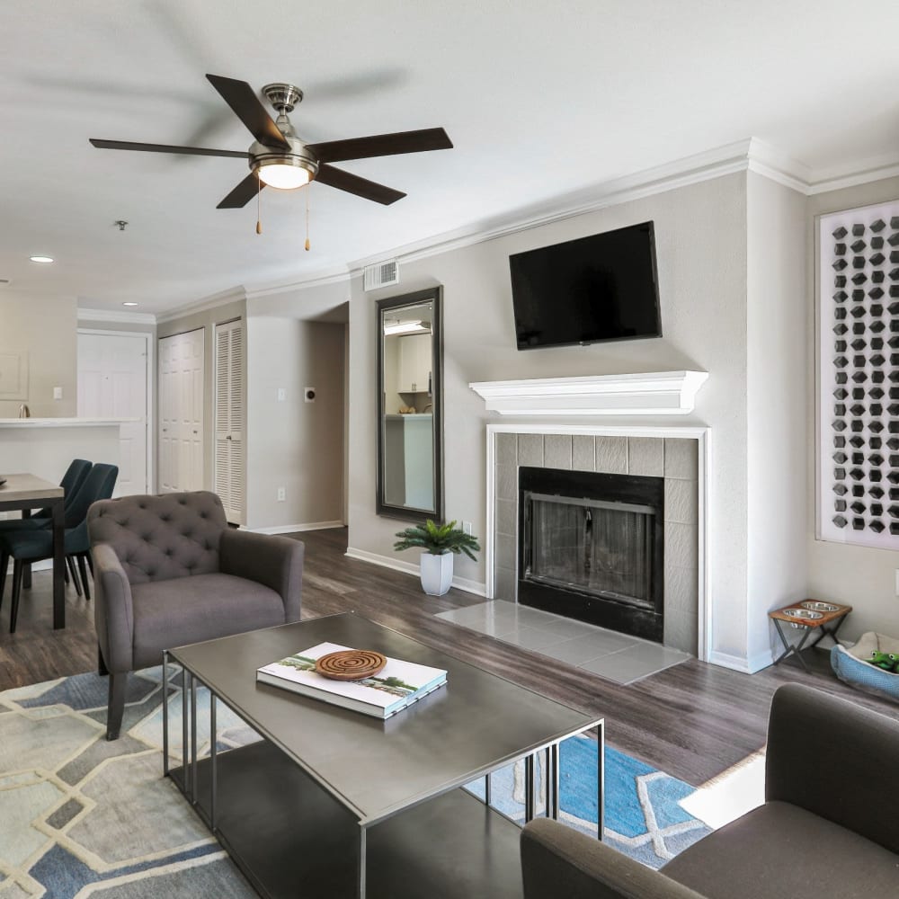 Spacious living room with tv, fireplace, and a ceiling fan at 45Eighty Dunwoody Apartment Homes in Dunwoody, Georgia