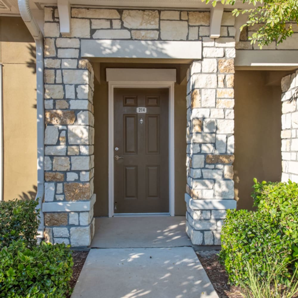 Apartment front door with brick accents at Avenues at Tuscan Lakes, League City, Texas