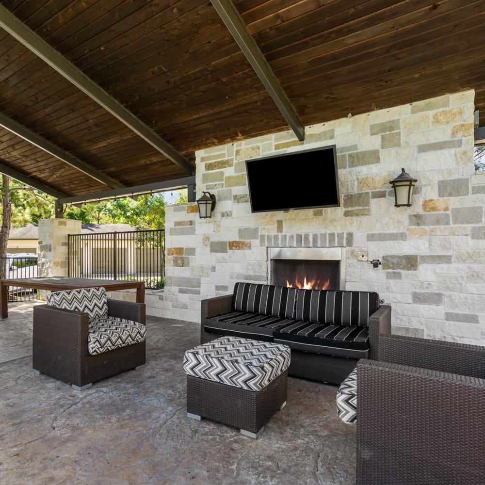 Covered patio lounge with fireplace at Discovery at Kingwood in Kingwood, Texas